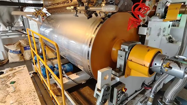 cast-stretch-film-flat-die Molten polymer leaving a flat die to form cast stretch film
