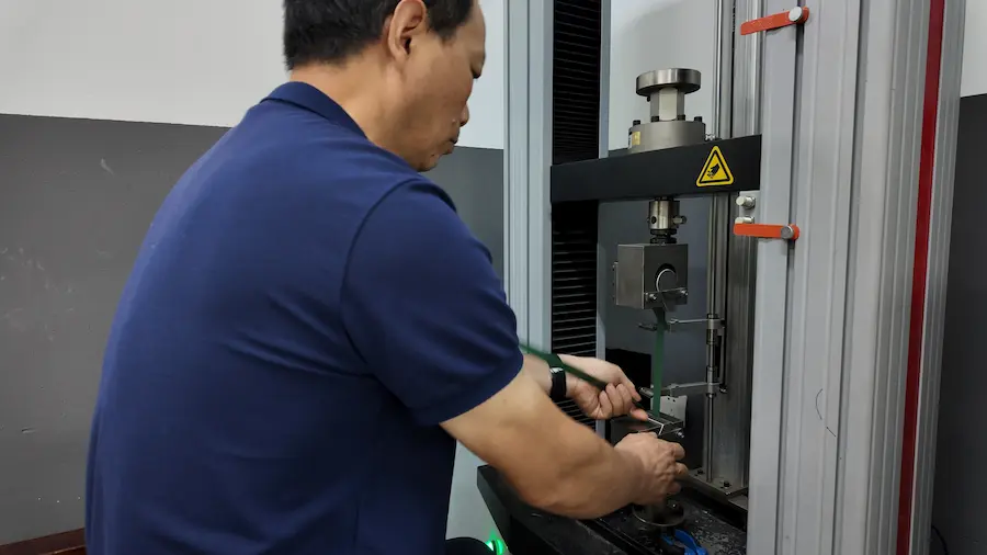 pet-strapping-tensile-test PET strapping sample held in tensile testing machine grips
