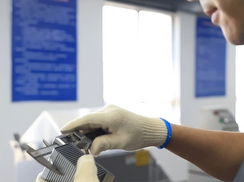 Juhong lab engineer using a high-precision digital micrometer to measure strapping seal thickness, ensuring strict &plusmn;0.035mm tolerance compliance with GB/T 39040-2020 standards