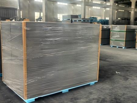 Industrial-grade stretch film protecting gypsum boards on pallets at a manufacturing facility, demonstrating superior puncture resistance and high tensile strength for heavy construction materials.