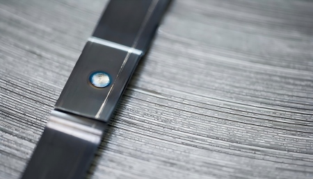 Close-up of Spot-weld Sealless Joints: Illustrating the permanent, sealless closure achieved by friction or heat welding on steel strapping.