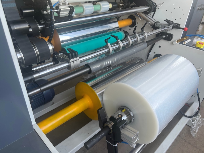 Jumbo Stretch Film Master Roll feeding the high-speed slitting machine for manufacturing retail and industrial stretch rolls