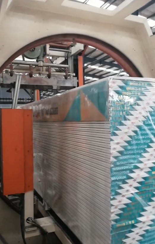 Machine Stretch Film application on palletized drywall sheets for construction logistics