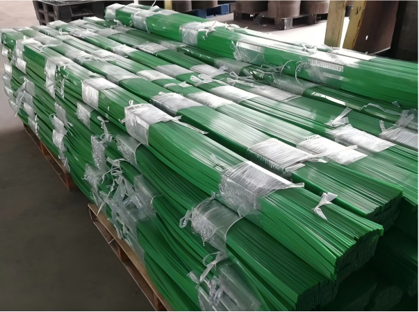 A high-quality industrial photograph of Juhong Packing’s pre-cut PET baling straps, specifically manufactured for the cotton and synthetic fiber industries. These straps are pre-cut to exact lengths to guarantee a consistent circumference for every compressed bale, which is essential for stable container stacking and safe export logistics. Designed for manual and semi-automatic baling, these high-tensile polyester straps provide a rust-proof, safe alternative to steel wire, offering superior load retention for high-expansion materials.