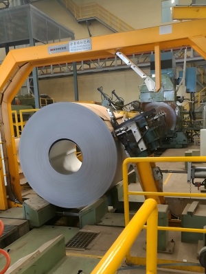 High-tensile steel strapping manufactured by Juhong, shown operating smoothly within a Signode automatic industrial strapping machine for heavy-duty applications.