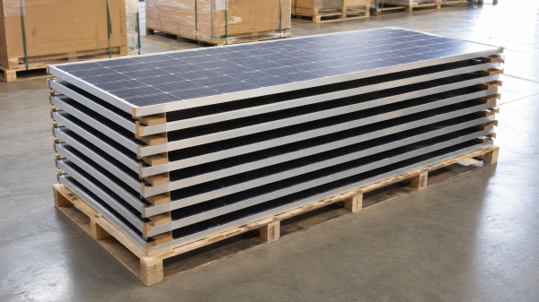 Stacked solar modules on a pallet before PET strapping, with small gaps between layers