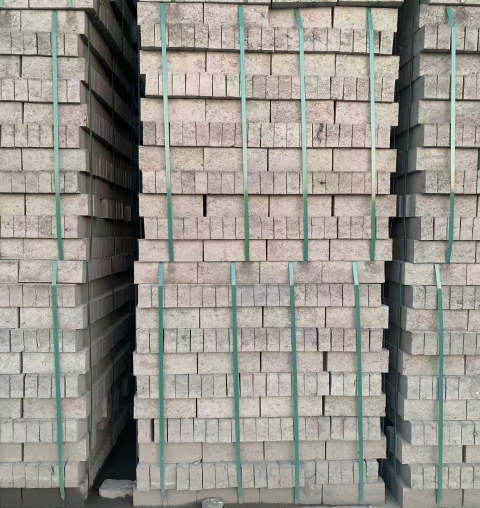 Juhong Packing\'s AAR-certified green PET strapping (ID: 124) used for bundling industrial bricks in an outdoor factory setting. This UV-stabilized banding provides superior elastic memory to maintain tension and load stability for masonry products stored in harsh environmental conditions.