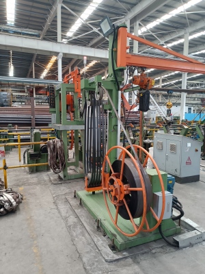 High-tensile blue tempered steel strapping from Juhong Packing Materials being used with a Generica automatic strapping system for heavy-duty industrial load securing.