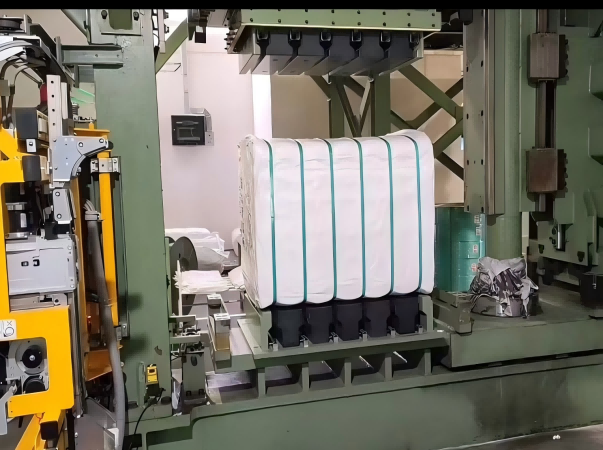 A high-performance photograph of a fully automated textile packaging line utilizing Juhong Packing’s machine-grade PET jumbo rolls. The image demonstrates the seamless integration of our precision-engineered strapping into high-pressure fiber balers. By using these high-capacity jumbo coils, manufacturers significantly reduce downtime for roll changes while ensuring a constant, high-tension securement of cotton and synthetic fiber bales. This rust-proof, cost-effective solution is optimized for 24/7 robotic production environments, ensuring zero contamination of premium fibers.
